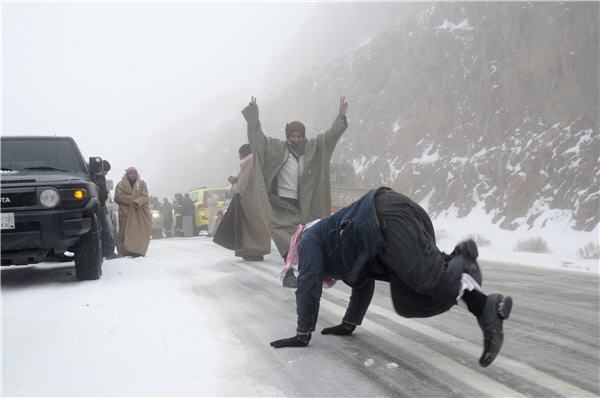 Saudi-Orang-orang bergembira bermain salju setelah badai salju di dekat padang pasir Tabuk, sekitar 1.500 km dari Riyadh, Rabu (9-1-2013). (Reuters-Mohamed Alhwaity)-6-jpeg.image