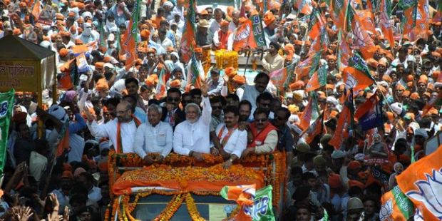 India-Narendra Modi (tengah), melambaikan tangannya kepada ribuan pendukung yang menyambutnya di kota Varanasi-jpeg.image